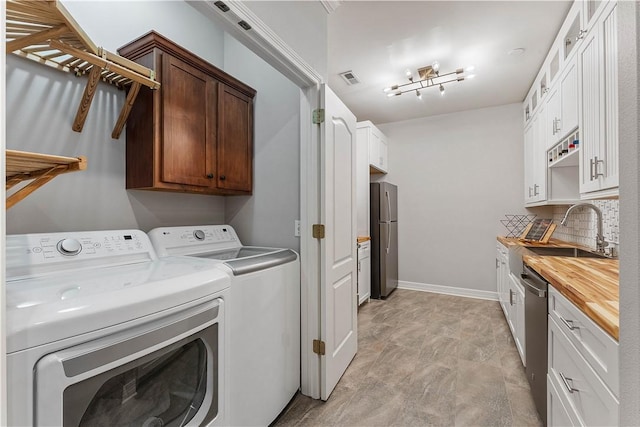 laundry room featuring independent washer and dryer, laundry area, a sink, and visible vents