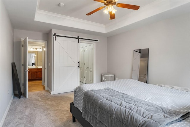 bedroom featuring crown molding, a tray ceiling, light colored carpet, a barn door, and baseboards