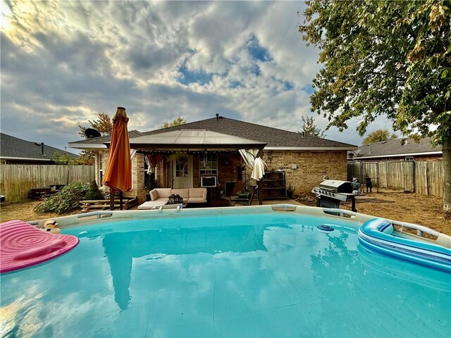 view of pool featuring an outdoor living space, a patio, a fenced backyard, and a grill