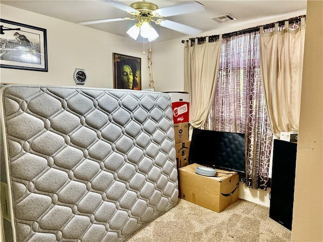 carpeted bedroom featuring visible vents and a ceiling fan