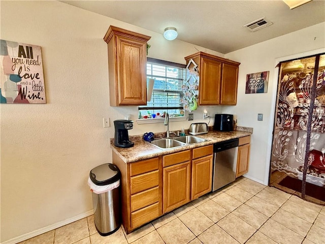 kitchen featuring stainless steel dishwasher, visible vents, brown cabinets, and a sink