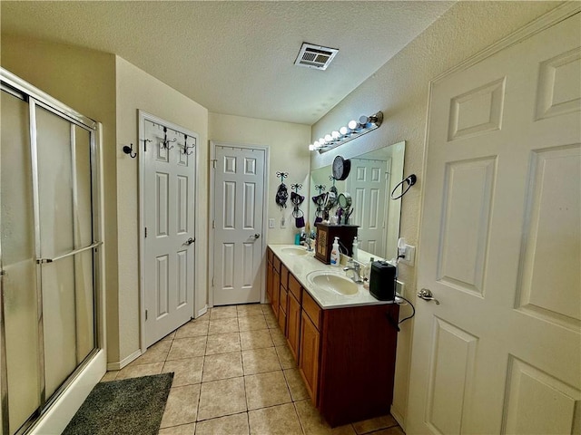 full bath featuring a shower stall, tile patterned floors, a sink, and visible vents