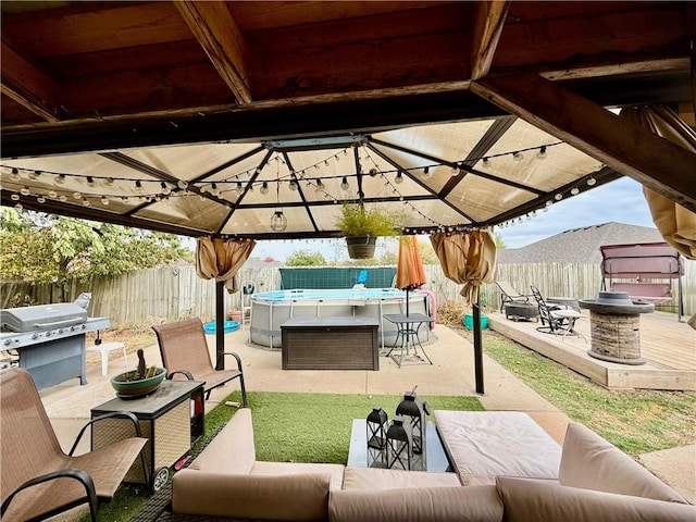 view of patio / terrace featuring an outdoor living space, a gazebo, a fenced backyard, and area for grilling