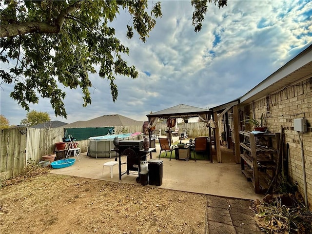 view of patio / terrace with a fenced in pool, a gazebo, and a fenced backyard
