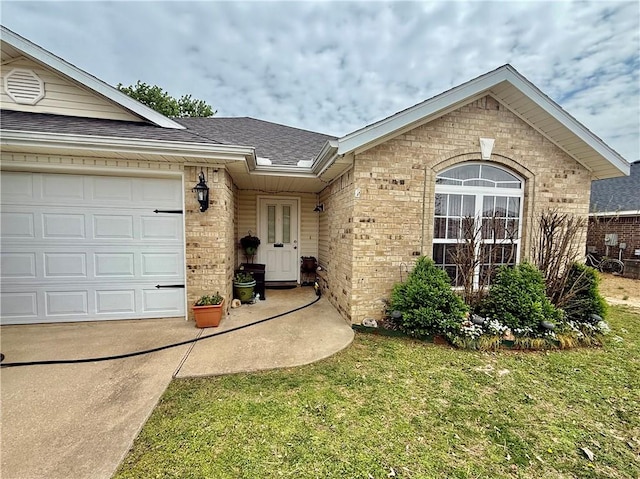 ranch-style home with roof with shingles, a front lawn, brick siding, a garage, and concrete driveway