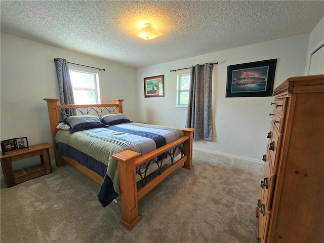 carpeted bedroom featuring baseboards, multiple windows, and a textured ceiling