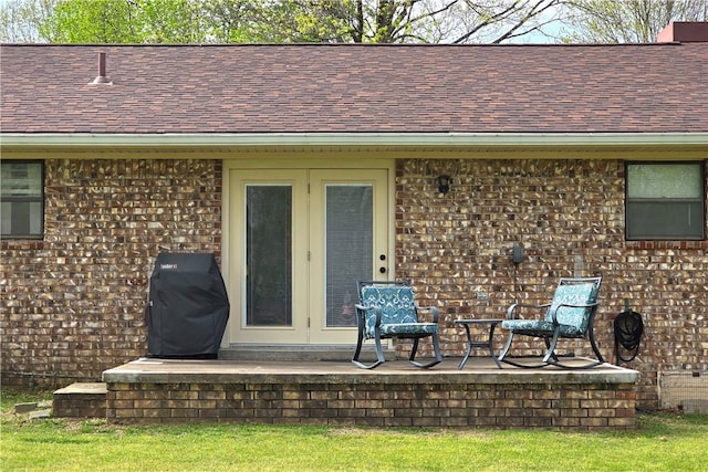 rear view of house featuring a patio, brick siding, and a shingled roof