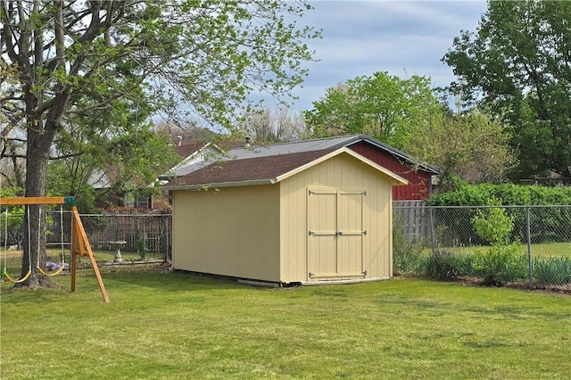 view of shed with a fenced backyard and a playground