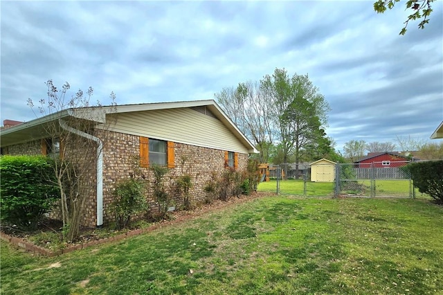 view of property exterior with a yard, brick siding, fence, and a gate