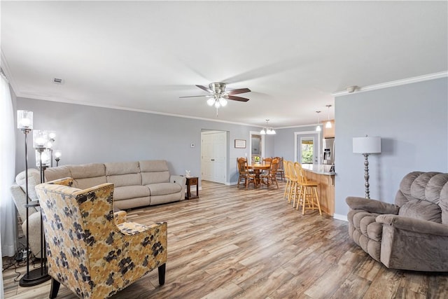19856 Keck Rd, Siloam Springs, AR 72761 - living area featuring a ceiling fan, light wood-style floors, ornamental molding, baseboards, and a chandelier