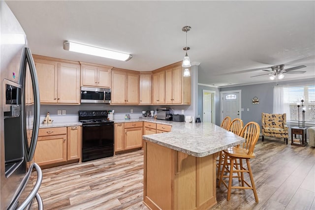 kitchen with appliances with stainless steel finishes, light wood-style floors, a peninsula, light brown cabinetry, and a breakfast bar area