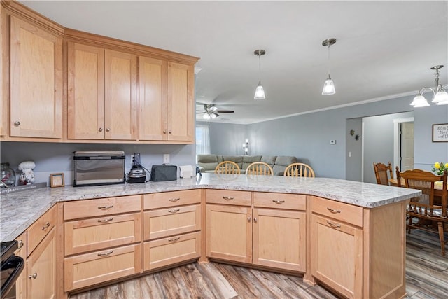 kitchen with a peninsula, light wood-style floors, light brown cabinets, and ceiling fan with notable chandelier