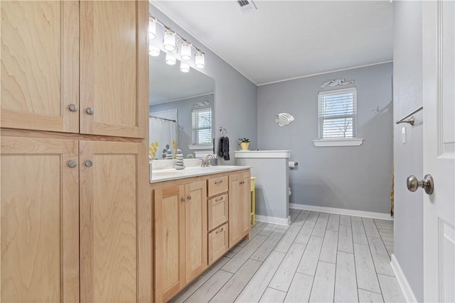 bathroom featuring vanity, baseboards, toilet, visible vents, and wood finished floors