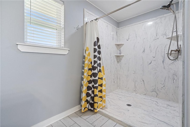 bathroom featuring a shower stall and baseboards