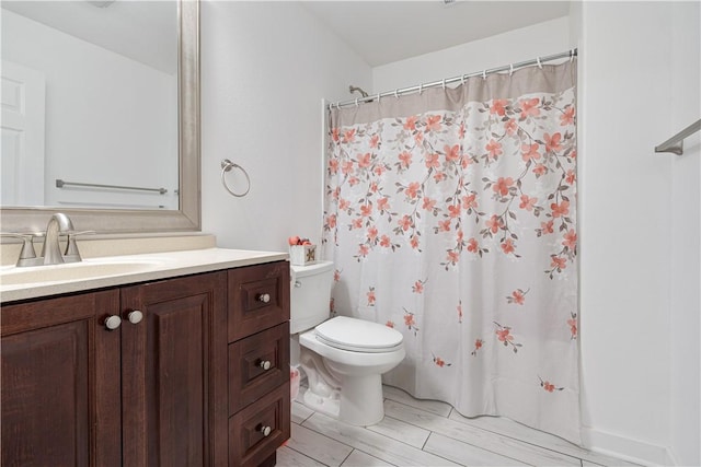 full bathroom featuring a shower with shower curtain, vanity, and toilet