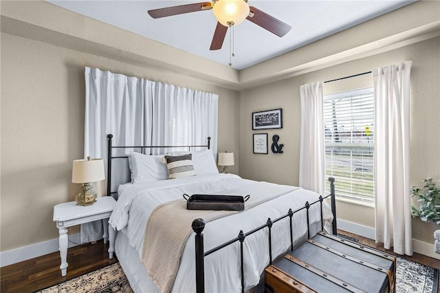 bedroom with ceiling fan, baseboards, and wood finished floors