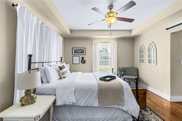 bedroom featuring wood finished floors, ceiling fan, and baseboards