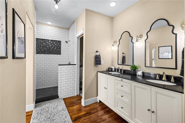 bathroom with a sink, toilet, a walk in shower, and baseboards