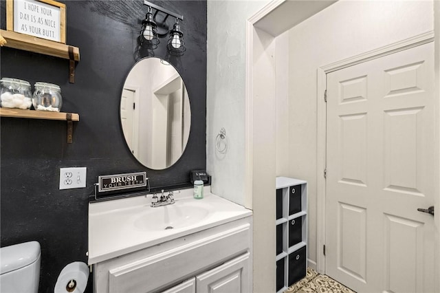 half bathroom featuring vanity and toilet