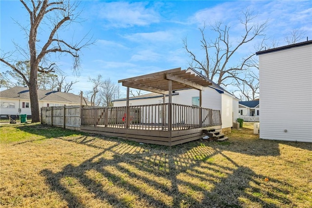 rear view of property featuring fence, a wooden deck, a lawn, and a pergola