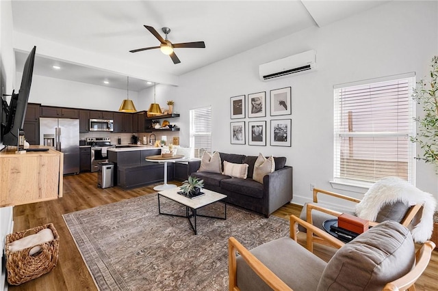 living room featuring recessed lighting, a wall unit AC, a ceiling fan, and wood finished floors