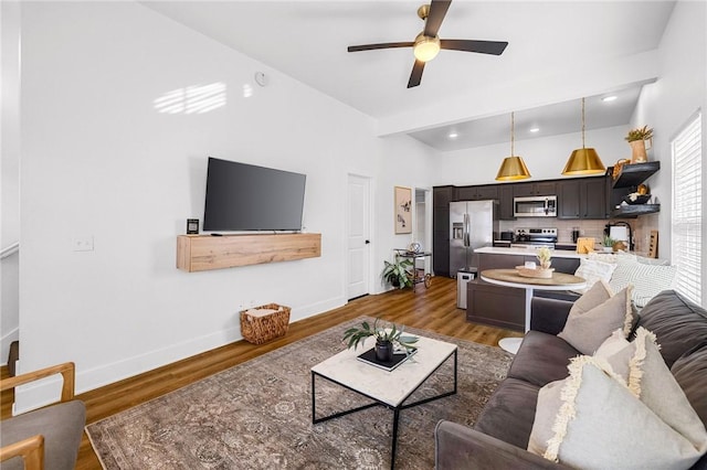 living area featuring wood finished floors, ceiling fan, and baseboards