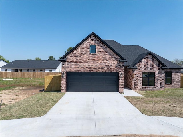 1900 Yellowstone Dr, Barling, AR 72923 - view of front of house featuring concrete driveway, a front yard, brick siding, a garage, and fence
