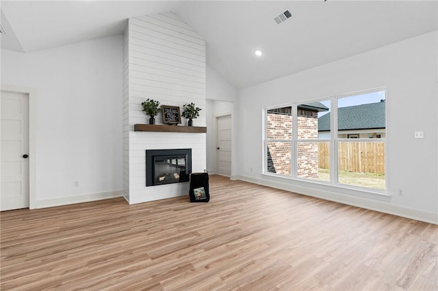1900 Yellowstone Dr, Barling, AR 72923 - unfurnished living room with visible vents, baseboards, light wood finished floors, a large fireplace, and high vaulted ceiling