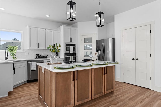 1900 Yellowstone Dr, Barling, AR 72923 - kitchen featuring a sink, light wood-style flooring, a kitchen island, and stainless steel appliances