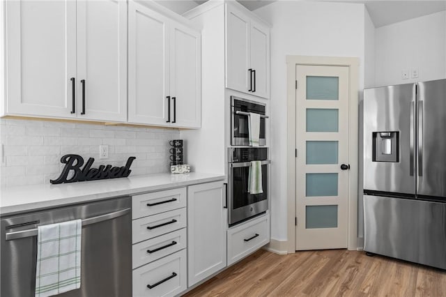 1900 Yellowstone Dr, Barling, AR 72923 - kitchen featuring light wood-style flooring, white cabinetry, appliances with stainless steel finishes, wine cooler, and decorative backsplash