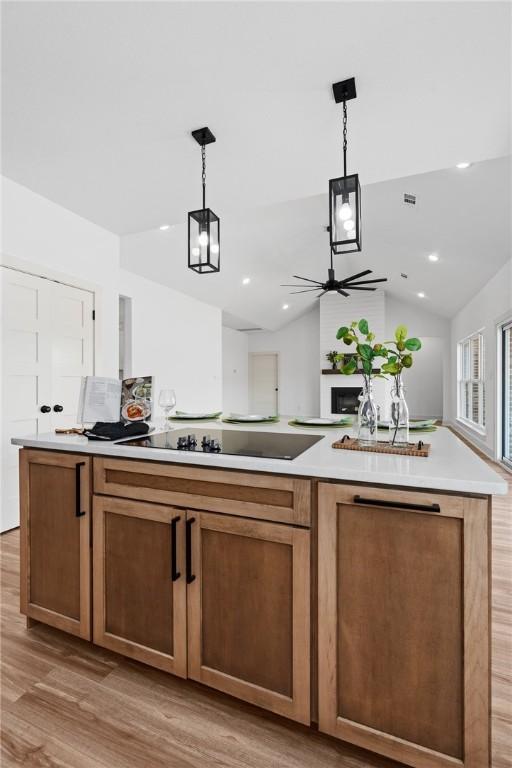 1900 Yellowstone Dr, Barling, AR 72923 - kitchen featuring light wood-style flooring, light countertops, a kitchen island, decorative light fixtures, and ceiling fan