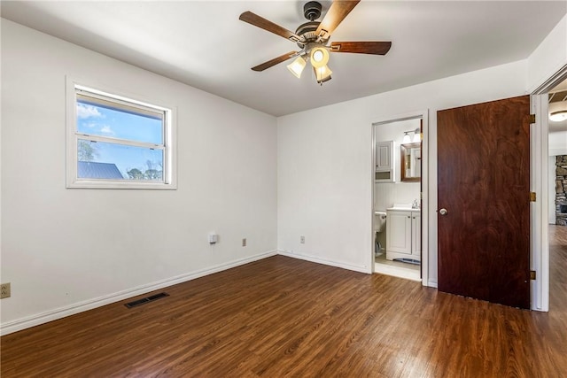unfurnished bedroom with visible vents, baseboards, a ceiling fan, ensuite bath, and wood finished floors