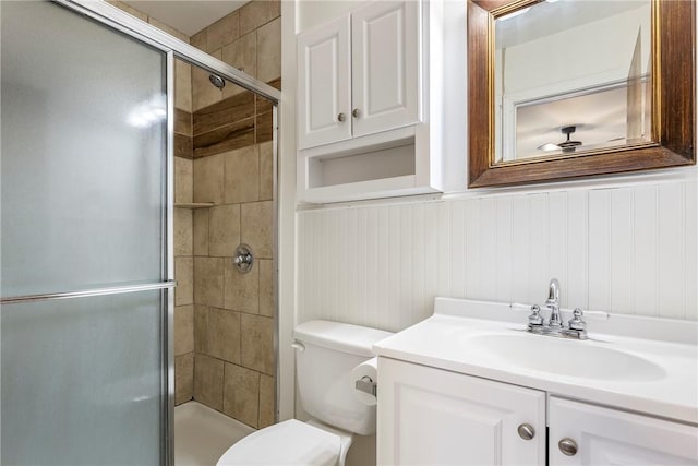 bathroom with a shower stall, vanity, and toilet