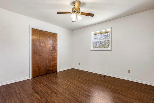 unfurnished bedroom with visible vents, baseboards, a closet, a ceiling fan, and wood finished floors