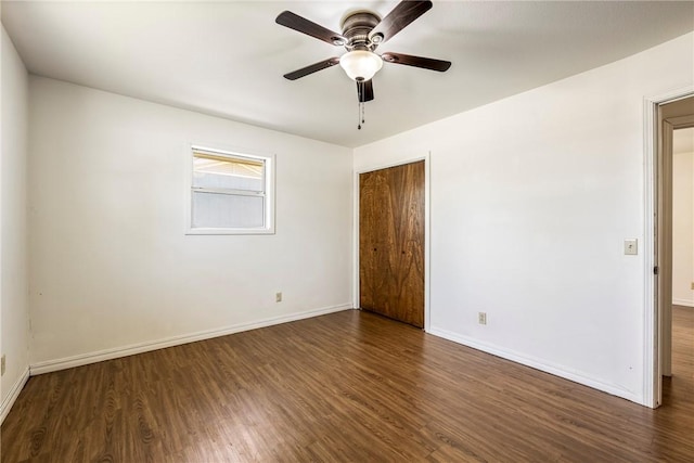 unfurnished bedroom featuring dark wood-type flooring, a closet, ceiling fan, and baseboards