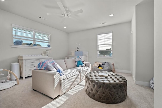 living room featuring healthy amount of natural light, light carpet, ceiling fan, recessed lighting, and baseboards