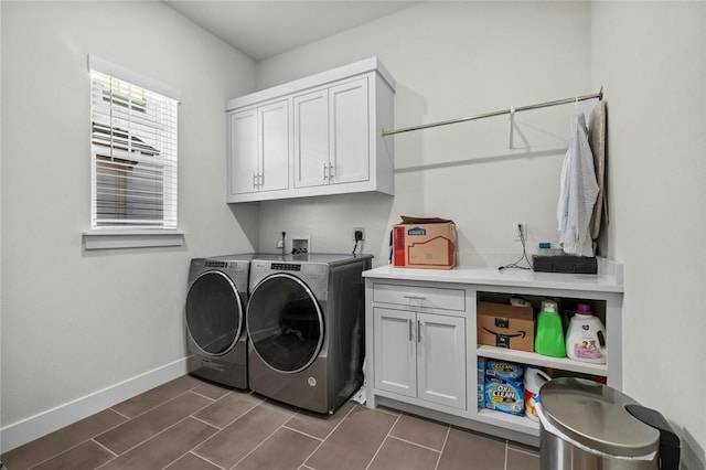 washroom with independent washer and dryer, cabinet space, and baseboards