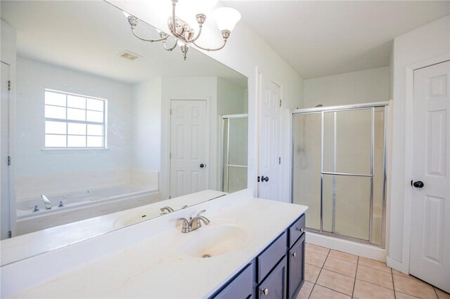 bathroom featuring a notable chandelier, vanity, tile patterned flooring, a shower stall, and a bath