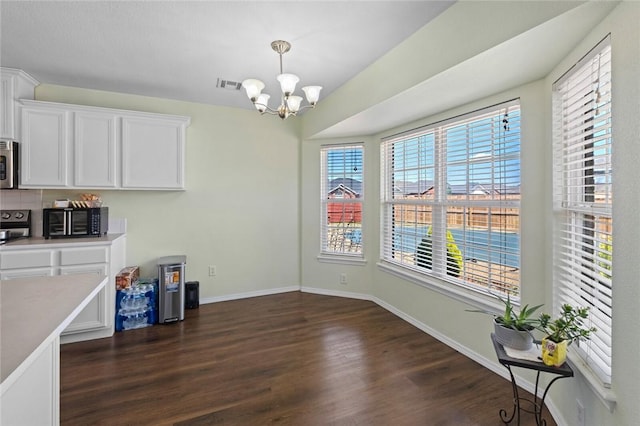 1901 SW Columbus Rd, Bentonville, AR 72713 - unfurnished dining area with a chandelier, dark wood-style flooring, and baseboards