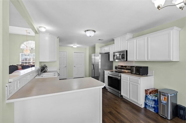 1901 SW Columbus Rd, Bentonville, AR 72713 - kitchen featuring appliances with stainless steel finishes, a sink, a chandelier, dark wood-type flooring, and white cabinets