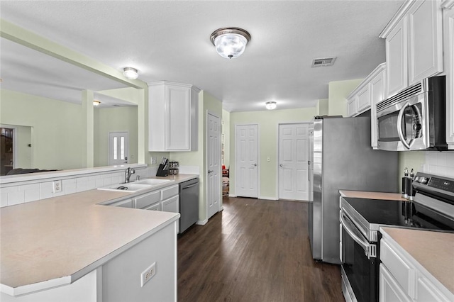 1901 SW Columbus Rd, Bentonville, AR 72713 - kitchen with stainless steel appliances, a sink, white cabinetry, and light countertops