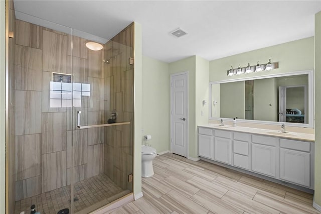1901 SW Columbus Rd, Bentonville, AR 72713 - bathroom with a shower stall, double vanity, toilet, and baseboards