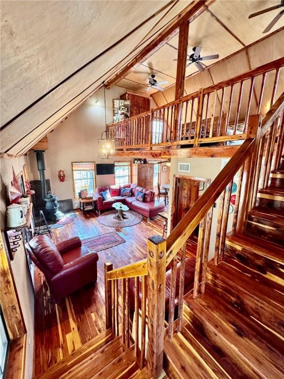 23045 Liberty Trl, Natural Dam, AR 72948 - interior space with visible vents, a wood stove, ceiling fan, wood-type flooring, and high vaulted ceiling
