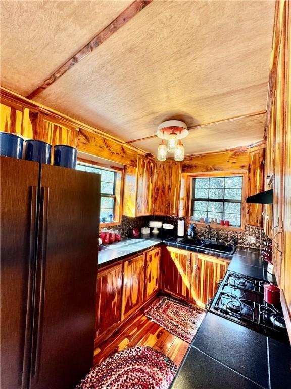 23045 Liberty Trl, Natural Dam, AR 72948 - kitchen with a textured ceiling, black appliances, a sink, wooden walls, and tile counters