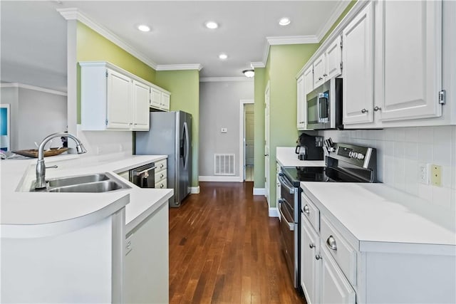 kitchen featuring visible vents, a sink, appliances with stainless steel finishes, a peninsula, and recessed lighting
