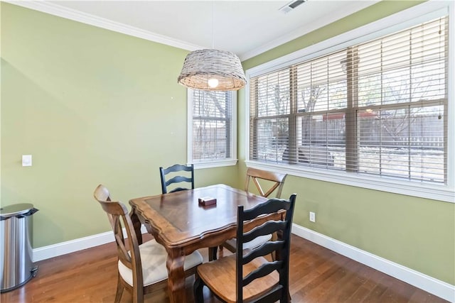 dining area featuring crown molding, visible vents, baseboards, and wood finished floors