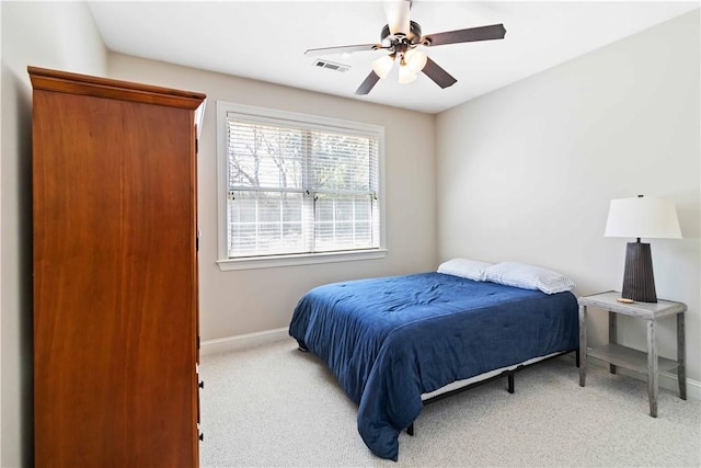 carpeted bedroom with visible vents, baseboards, and a ceiling fan
