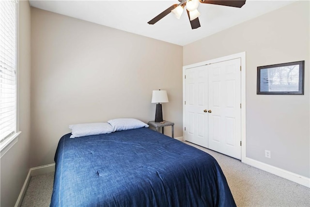 bedroom with a closet, baseboards, ceiling fan, and carpet