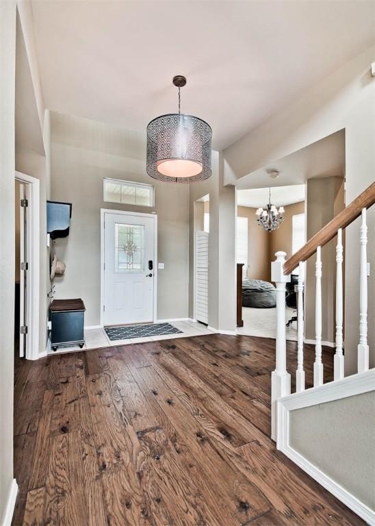 foyer featuring an inviting chandelier, wood finished floors, and baseboards