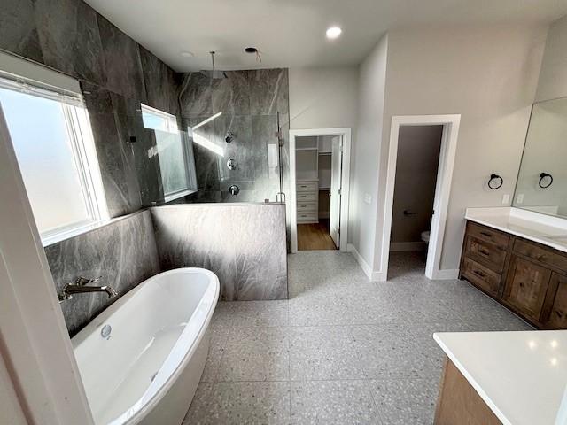 7919 Via Roma Ave, Springdale, AR 72762 - bathroom with a walk in shower, vanity, a soaking tub, toilet, and baseboards